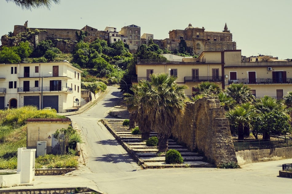 Pastel-colored houses climbing a hillside in Sambuca, Sicily